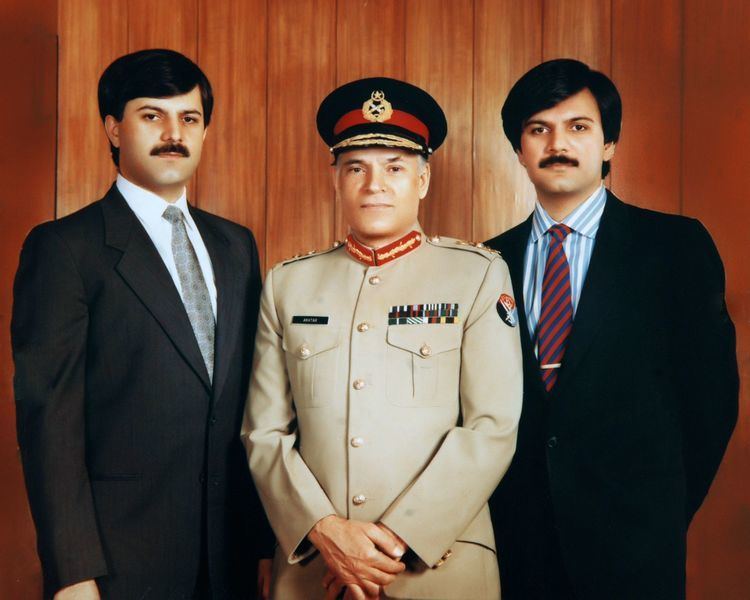 Humayun Akhtar Khan, Akhtar Abdur Rahman, Haroon Akhtar Khan (from left to right) in 1987 standing next to each other with serious faces. Humayun wearing a black coat, white long sleeve, and gray necktie, Akhtar wearing a black peaked cap and brown long sleeve with insignia and badges while Haroon wearing a black coat, a white and blue striped long sleeve, and a maroon and blue striped necktie