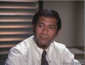 Al Harrington wearing white long sleeves and a black necktie in a scene from the 1968 tv series Hawaii Five-O