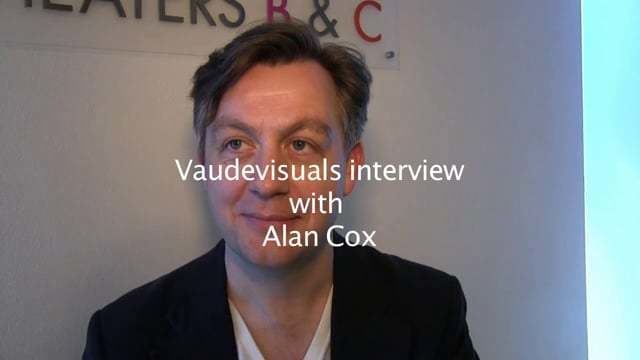 Alan Cox with a tight-lipped smile while wearing a white shirt under a black coat and a caption at the center saying, "Vaudesiduals interview with Alan Cox".