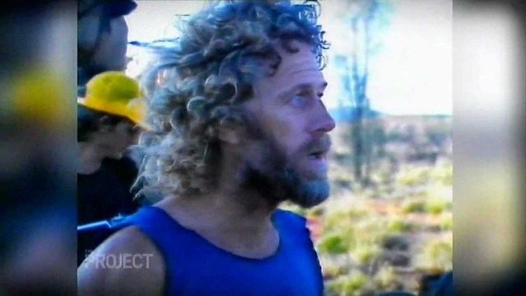 Alby Mangels looking afar, with mustache and beard, and wearing a blue sando