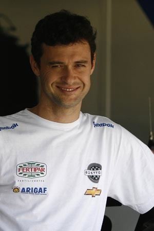 Alceu Feldmann smiling while wearing a white printed t-shirt