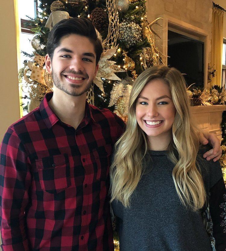 Alexandra Osteen smiling with her brother Jonathan Osteen in a Christmas Tree and wearing a dark gray shirt.