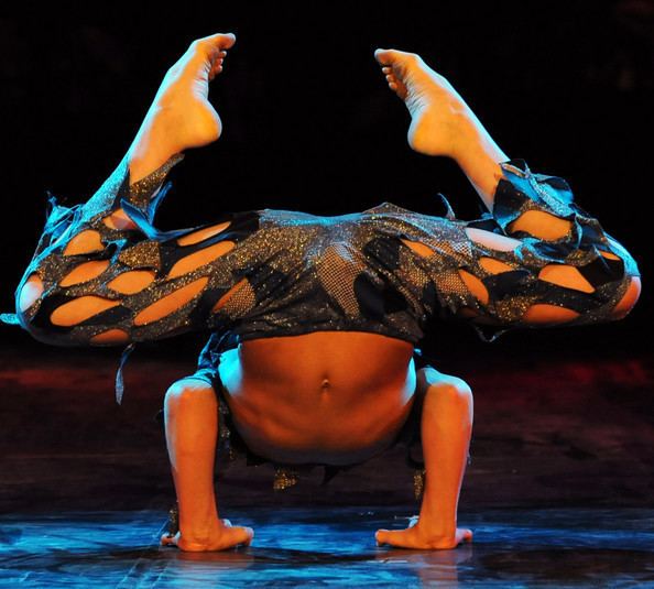 Alexey Goloborodko doing contortion with his hands on the floor and wearing a blue contortion costume.