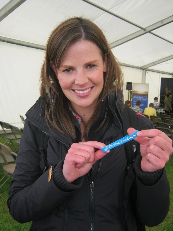 Alexis Green wearing black jacket while holding a blue silicon wristbands