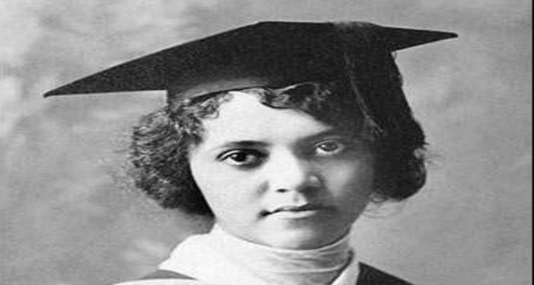 Alice Ball looking serious with curly hair and wearing a graduation gown and a black cap