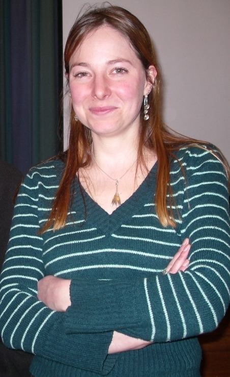 Standing Alice Roberts wearing a white and green sweatshirt