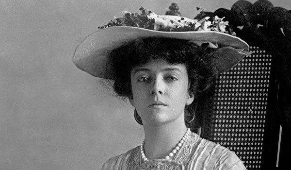 Alice Roosevelt sitting on a chair while wearing a hat and dress