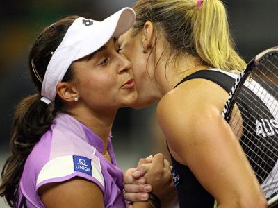 Alicia Molik kissing a woman while she is wearing a black and white top