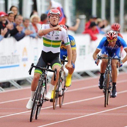 Alistair Donohoe in a cycling competition while wearing the white, green, and yellow jersey, black and green shorts, and white shoes
