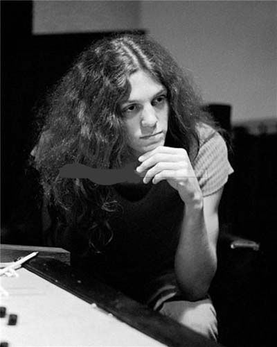 Allen Collins looking at something with his hand under his chin.