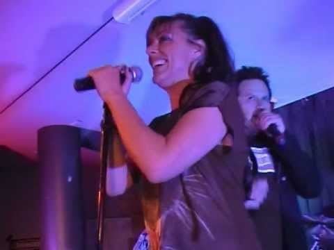 Ally Fowler singing while wearing a brown blouse