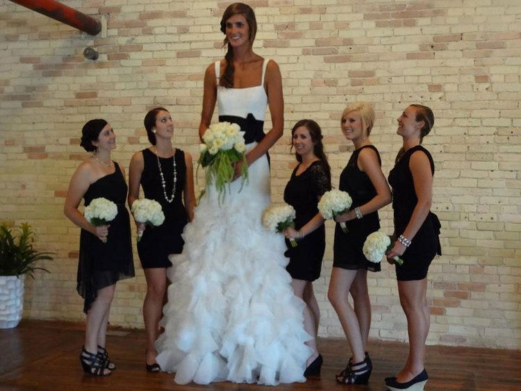 Allyssa DeHaan looking happy in a white gown during her wedding day together with her bridesmaids in their black dress