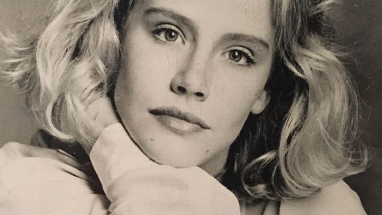 Amanda Peterson with a serious face, wavy blonde hair, and wearing a sweatshirt.