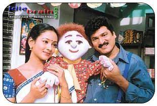 Rajendra Prasad and Uma smiling with the doll from 2001 movie, Ammo Bomma