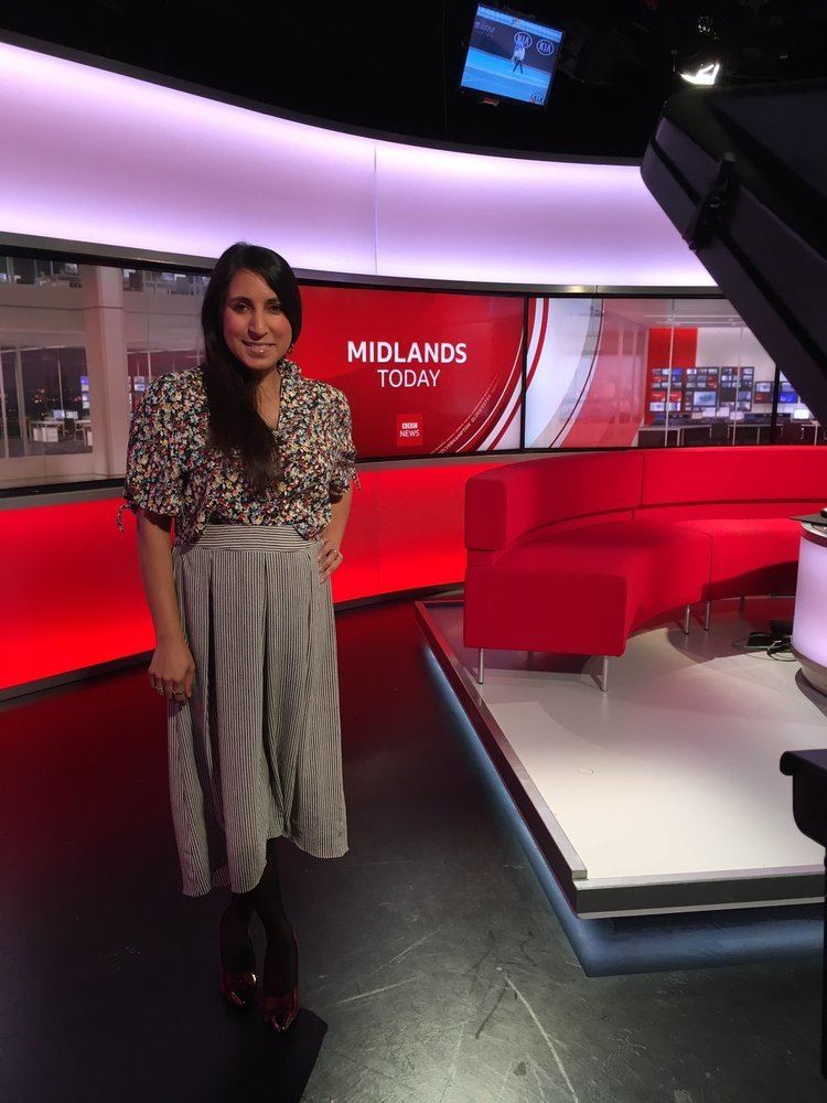 Amy Cole on "Midlands Today" wearing a flowered-pattern shirt and a long gray skirt