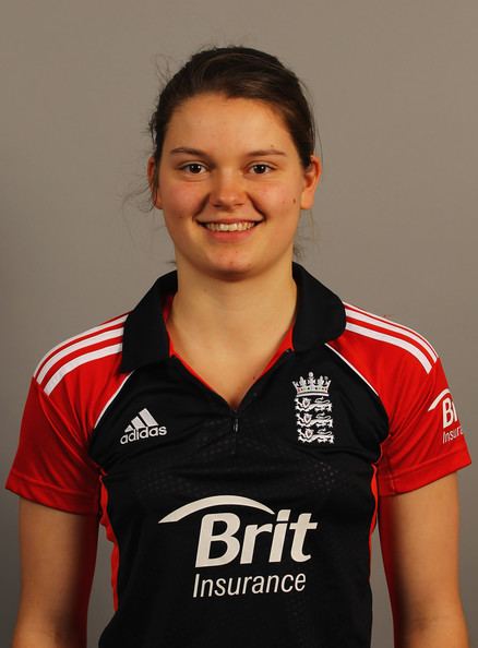 Amy Jones smiling while wearing a black, white and red polo shirt