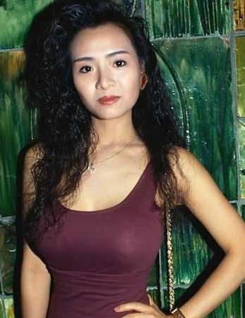 Amy Yip in her curly hair while wearing brown sleeveless