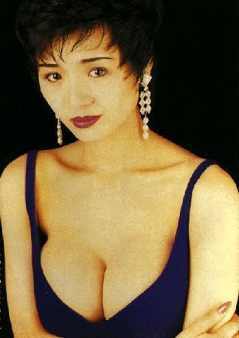 Amy Yip wearing earrings and sexy blue top