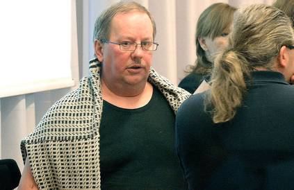 Anders Eklund at the court wearing eyeglasses and a black shirt surrounded by women.