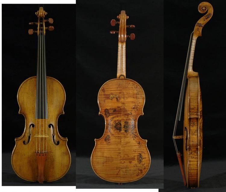 Made by Andrea Amati, a decorated violin with four strings, high arches, wide purfling, and elegantly curved scrolls and bodies in a front, back, and side view on a black background.