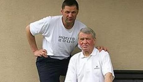 David Musli, son of Andrea Holíková, wearing a white shirt and black pants while holding an old man wearing a white polo shirt.