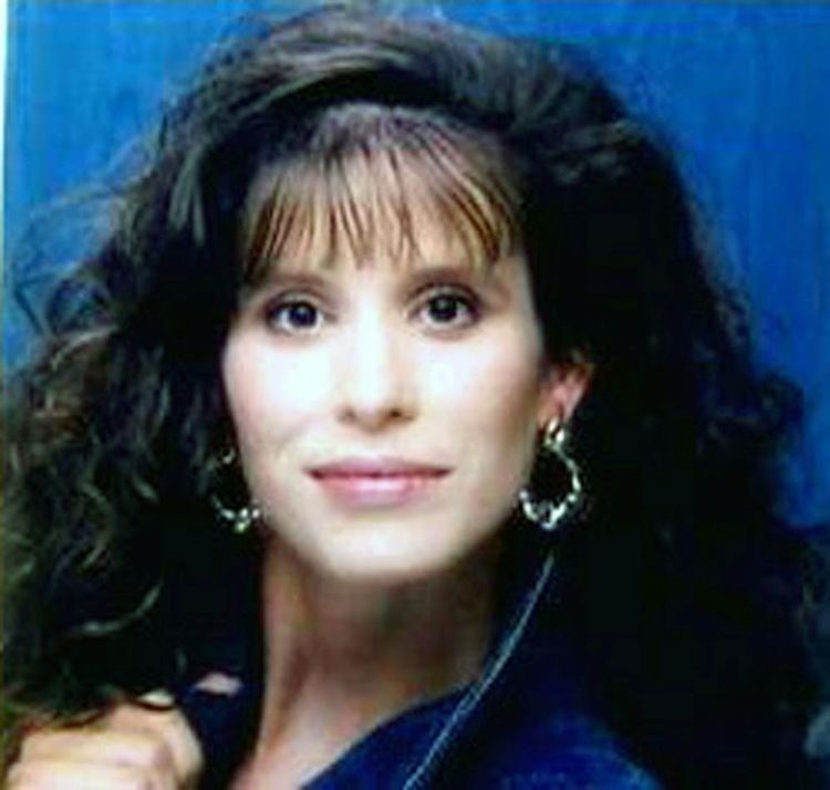 Andrea Yates smiling while wearing blue blouse and earrings