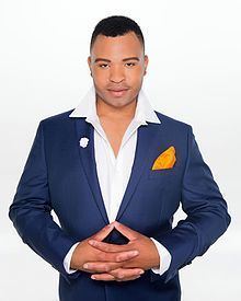 Andrew Chad Caldwell wearing a formal coat in a white background