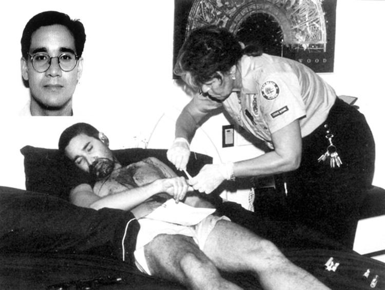 Andrew Cunanan's dead body found in a luxury houseboat lying on a couch with a police officer checking his dead body.