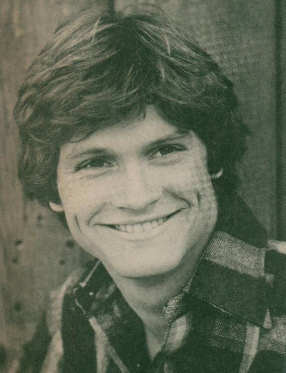 Andrew Stevens smiling while wearing a checkered polo