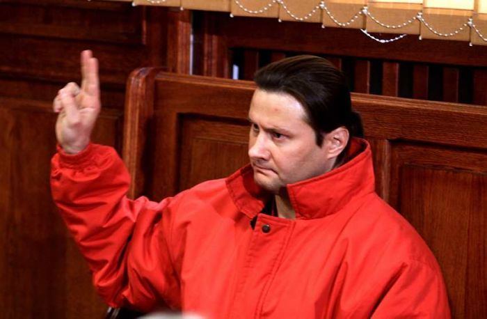 Ryszard Bogucki doing a peace sign while wearing a red jacket
