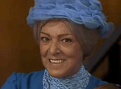 Angelines Fernández as Doña Cleotilde smiling while wearing a blue hat and blue dress in El Chavo del Ocho, 1973.