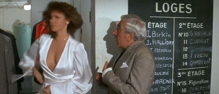 Raquel Welch is wearing a white long sleeve dress and Charles Gérard is wearing a gray coat in a scene from the 1977 French action comedy film, L'Animal