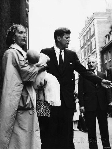 Lee Radziwill carrying her baby Anna Christina Radziwill outside guided by john f kennedy.