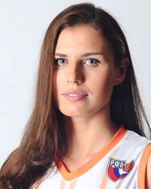 Anna Petrakova looking serious with her hair down, wearing an orange and white jersey with a logo