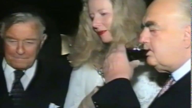 George Weidenfeld drinking wine while Annabelle Whitestone is beside him wearing a white gown during their wedding ceremony