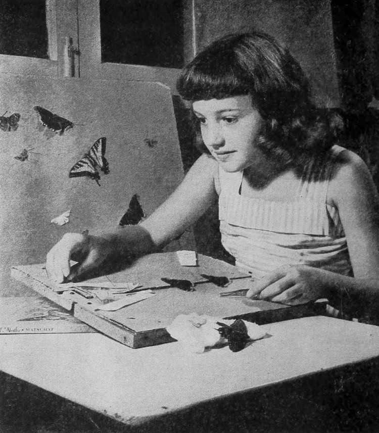 Young Anne Whitfield doing art while wearing a striped sleeveless blouse