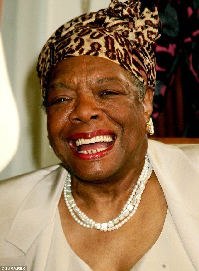 Annie Lee Cooper smiling, wearing red lipstick, a white beaded necklace, gold accentuated white earrings and a twisted animal-print turban. She is wearing a white dress under a dirty-white coat.