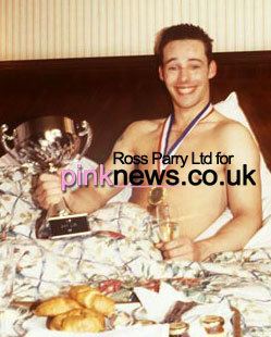 Anthony Morley smiling while holding a trophy and wearing a medal after winning Mr. Gay UK, 1993