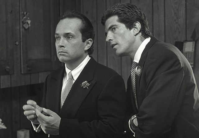 Anthony Stanislas Radziwill and John F. Kennedy Jr. looking afar  while wearing a coat, long sleeves, and necktie