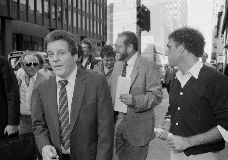 Anthony Spilotro wearing a suit and a striped tie surrounded by people.