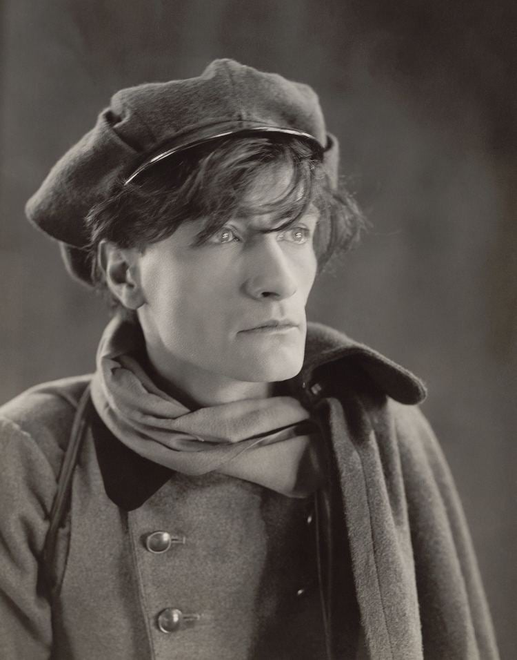 Antonin Artaud looking afar while wearing a hat, scarf, and coat