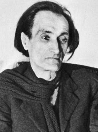 Antonin Artaud's sad face while wearing a coat and scarf