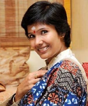 Anuradha Sriram smiling while wearing a blue and brown dress