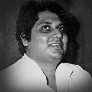 Anwar (singer) smiles while wearing a white collared shirt (black and white)