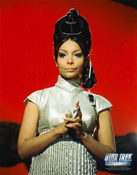 Arlene Martel as T'Pring in the movie "Star Trek (1966)",having a high bun hairstyle and wearing a white turtleneck dress