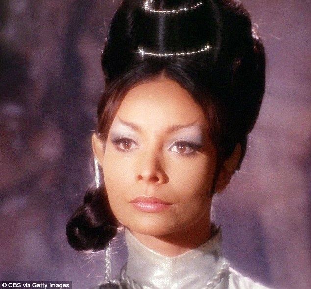 Arlene Martel as T'Pring in the movie "Star Trek (1966)", having a high bun hairstyle and wearing a white turtleneck dress
