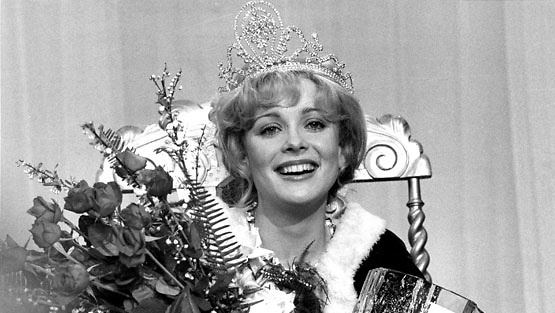 Armi Aavikko smiling and holding a bouquet while wearing a crown