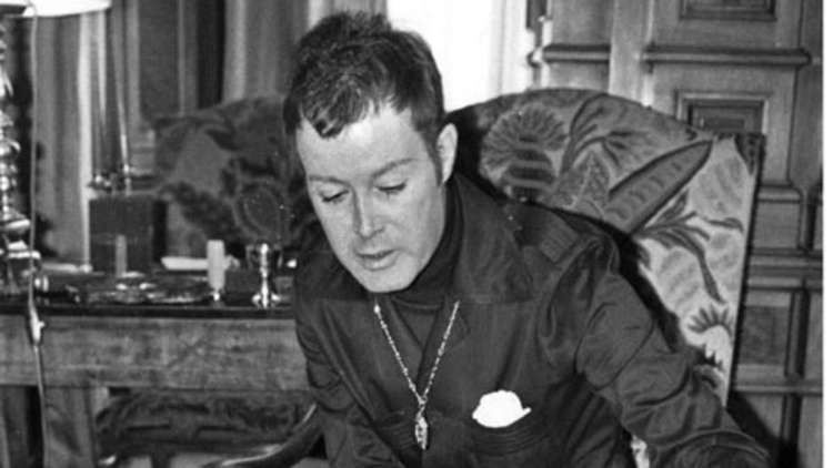 Arndt von Bohlen und Halbach sitting inside a room wearing a formal suit and a necklace.