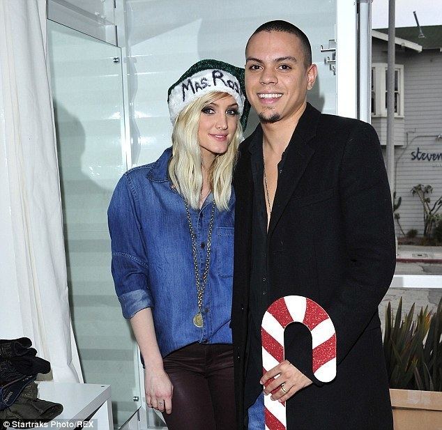 Ashlee Simpson smiling while wearing blue long sleeves and black and white hat while Evan Ross wearing a black long sleeves