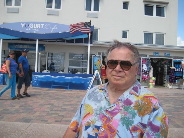 Art Metrano looking serious while wearing a colorful shirt and shades
